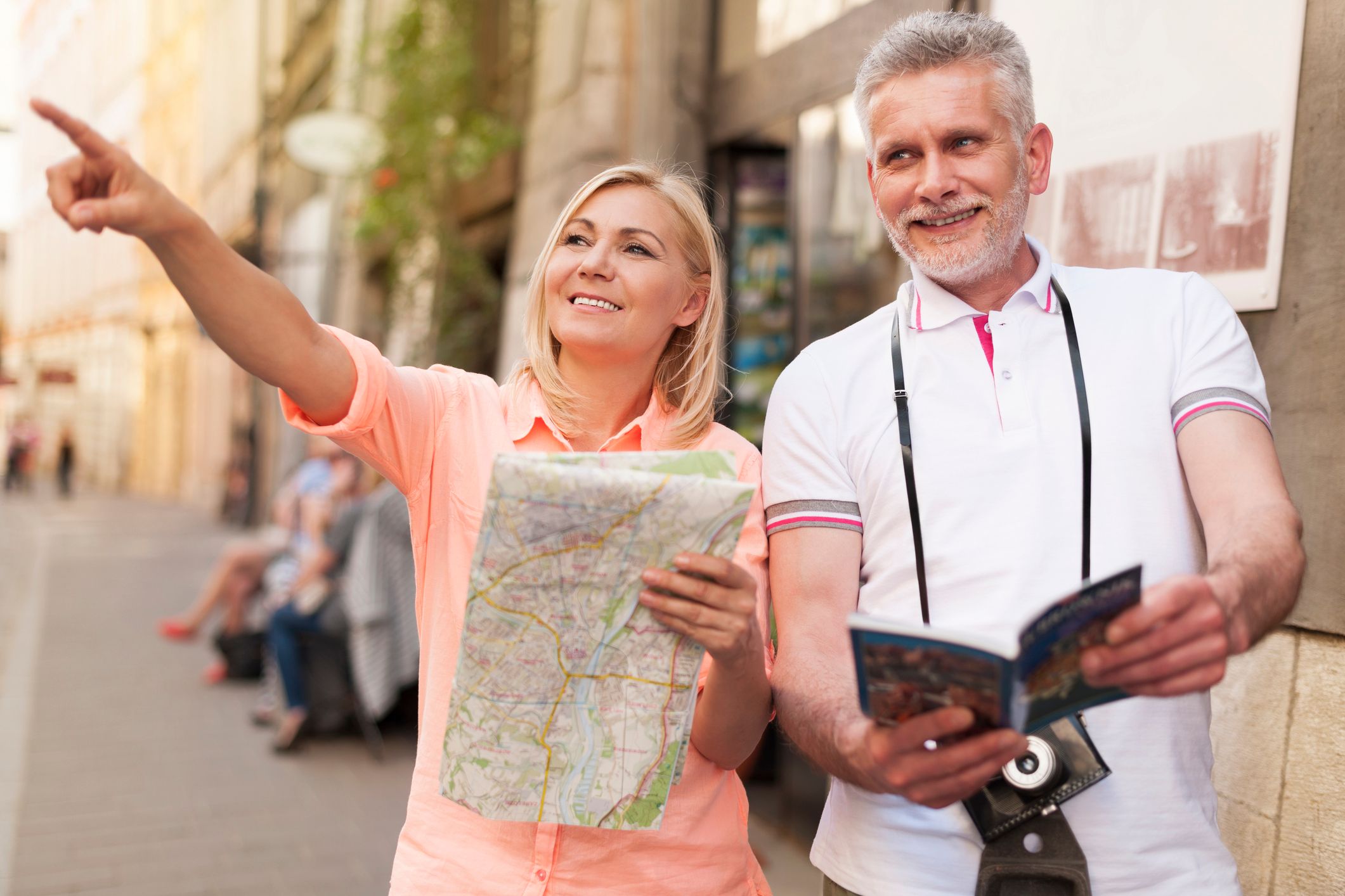 Paar im mittleren Alter schauen Stadtkarte und Reiseführer an